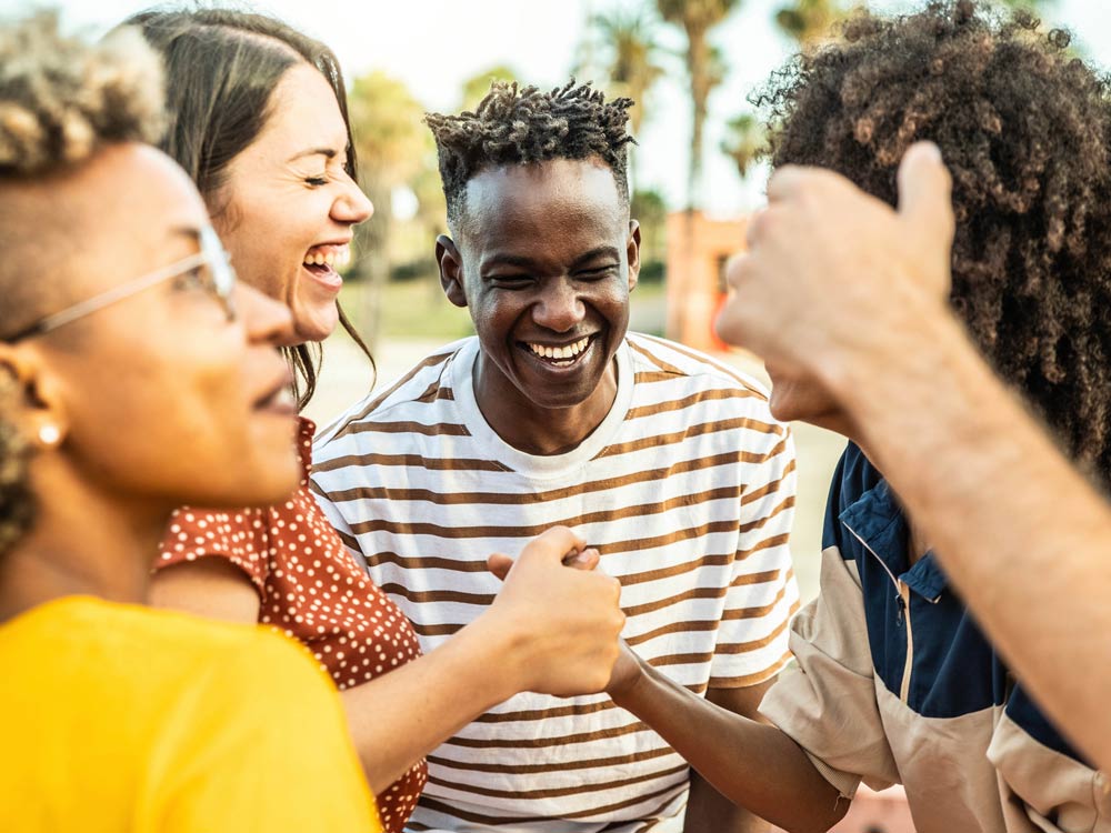 Multiracial best friends having fun laughing out loud outdoors